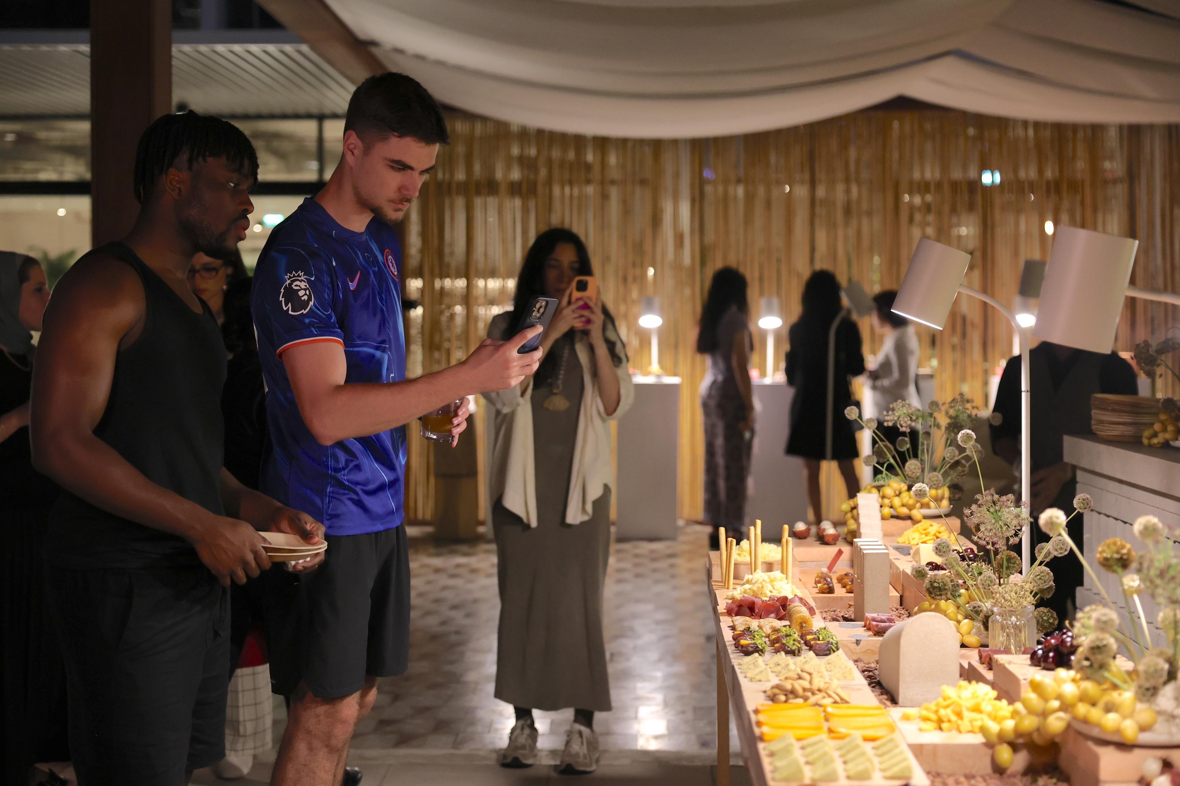 Attendees of the showcase event photographing the grazing scape.