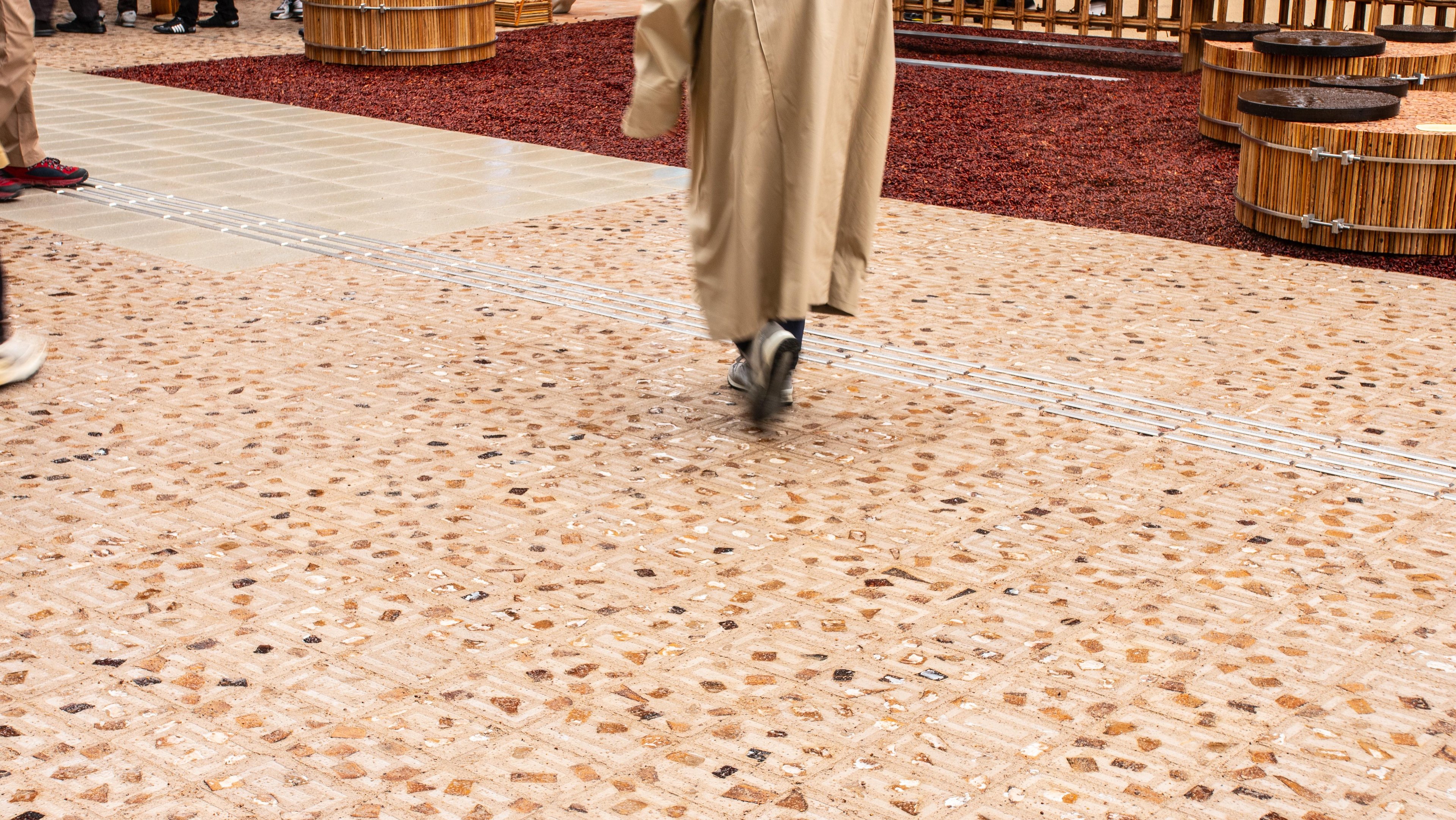 A pedestrian walking across a section of the Osaka floor paved with the palm-frond-imbued Datecrete pavers.