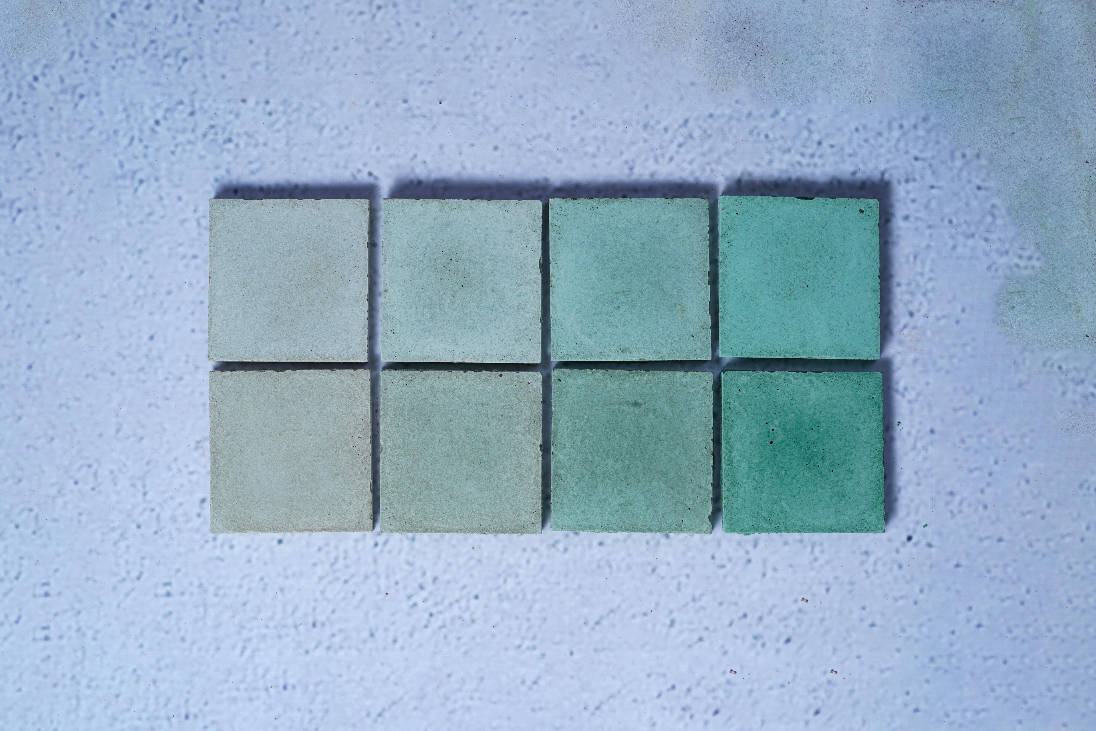 2 rows of 4 bricks in the style Emerald Green, with the first row showing the raw finish and the second showing the enhanced.