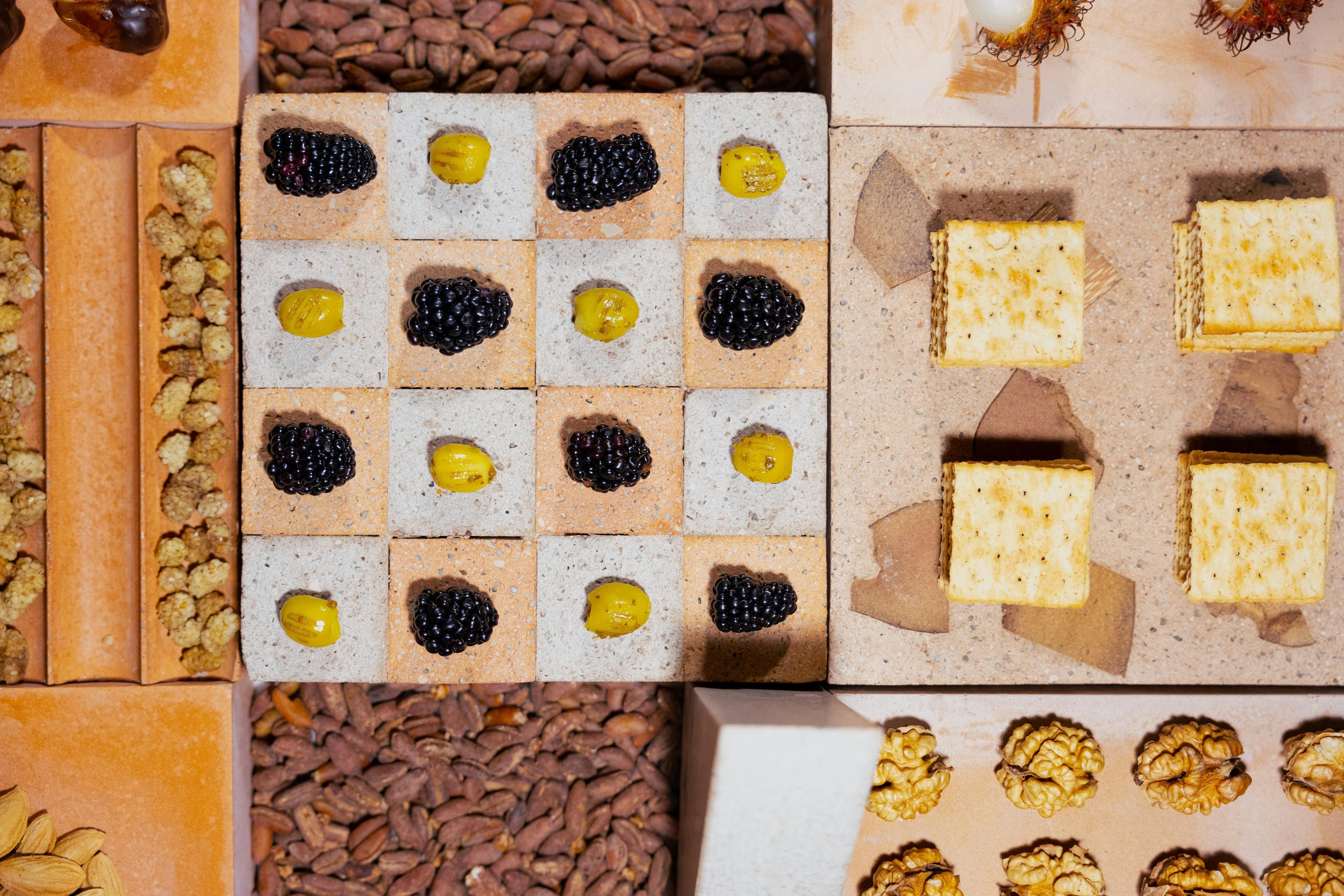 Overhead shot of the grazing scape, highlighting the different Datecrete styles and the different foodstuffs on top of it (crackers, walnuts, cheese, et cetera).
