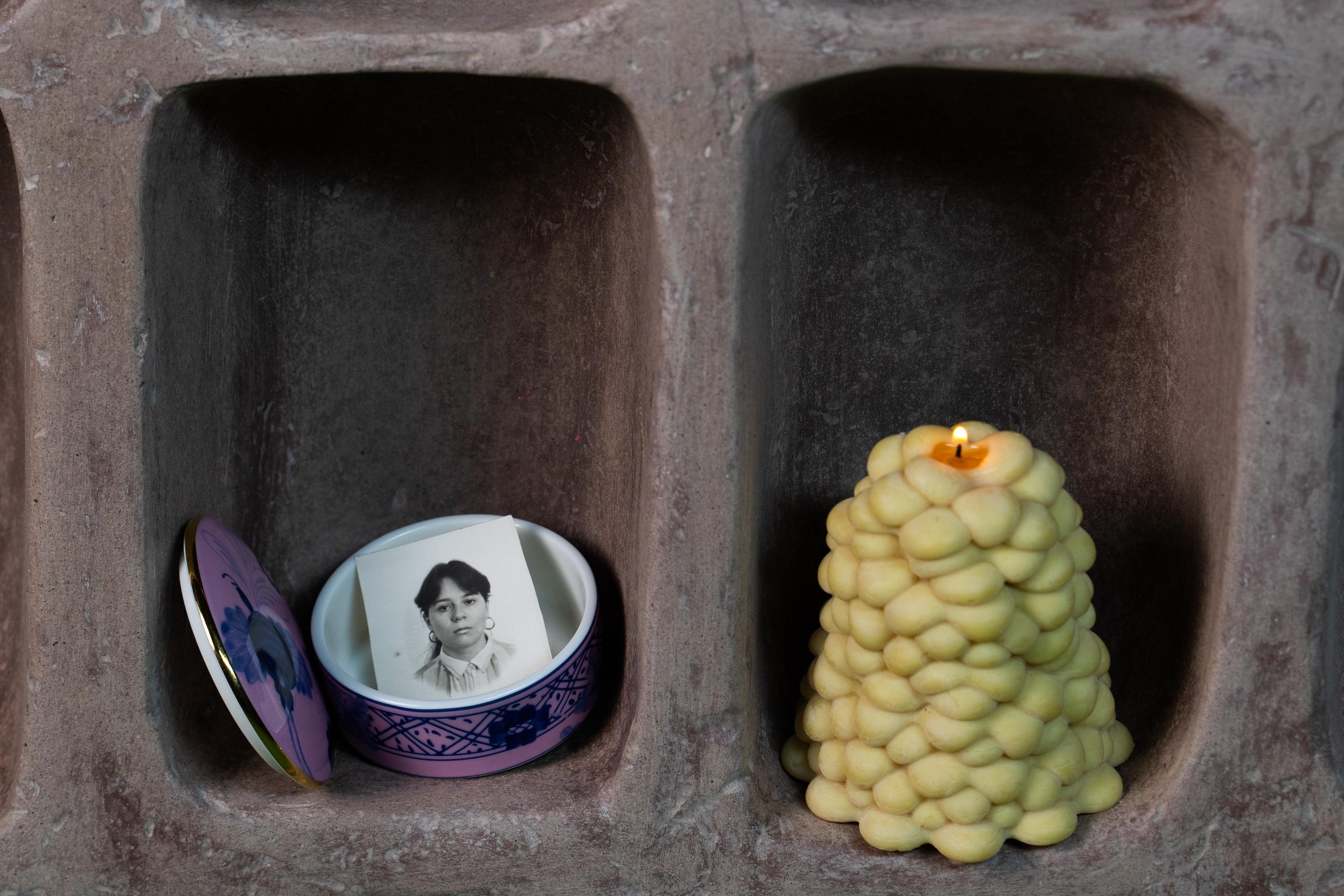 Close up shot of two neighboring slots in the Datecrete Vessel. The first slot is photographed with a trinket box, and the latter with a candle.