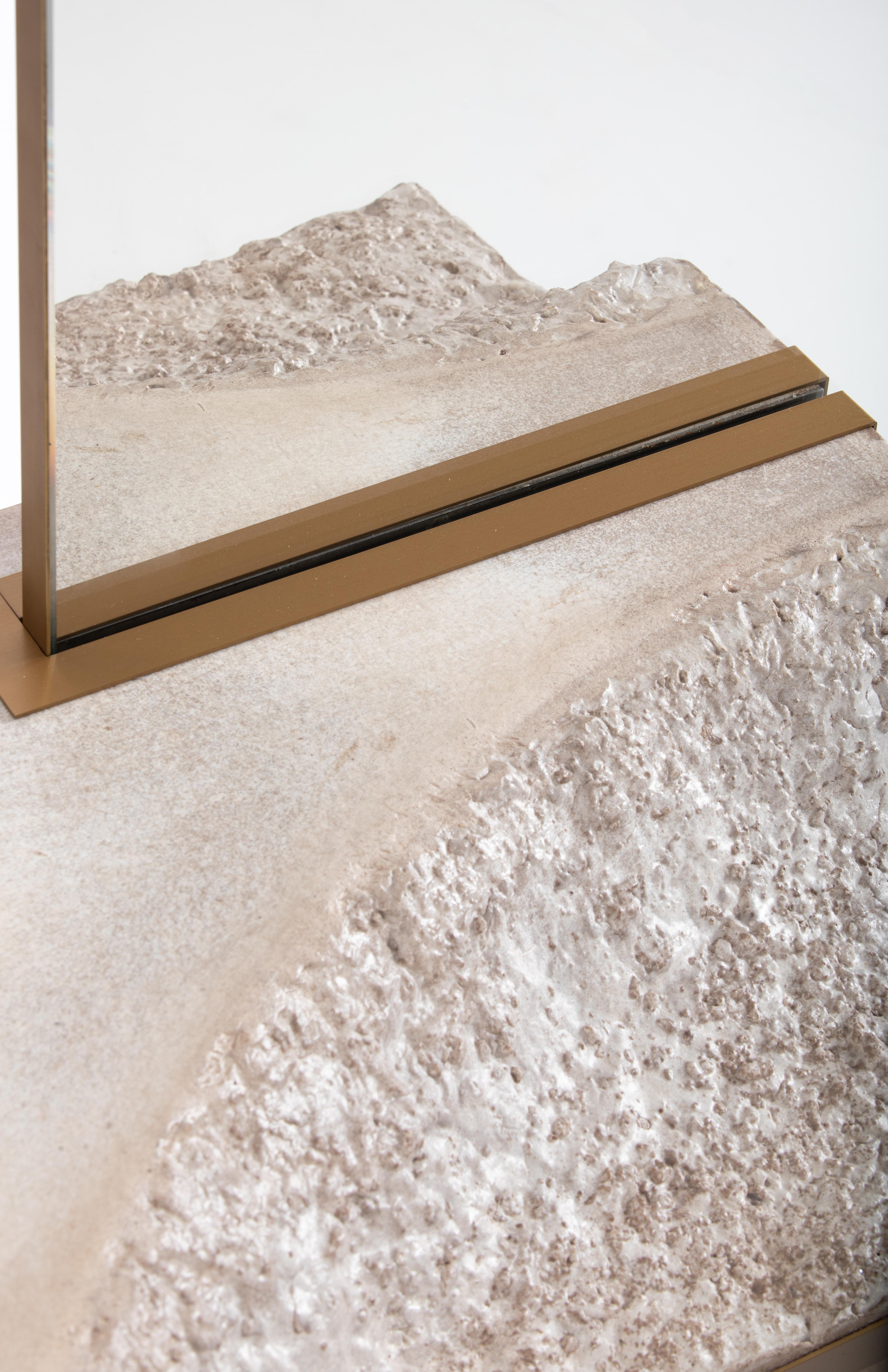 Close-up of the Datecrete Console, focusing on the bottom of the mirror, the brass lining, and the texture of the concrete.